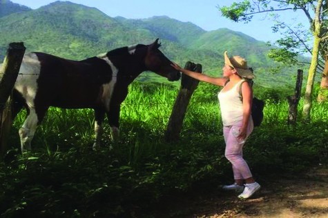 Scarlet Garcia touching a horse in Honduras.