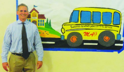 Principal Mr. Valdes next to one of the banners in the 1st building. 