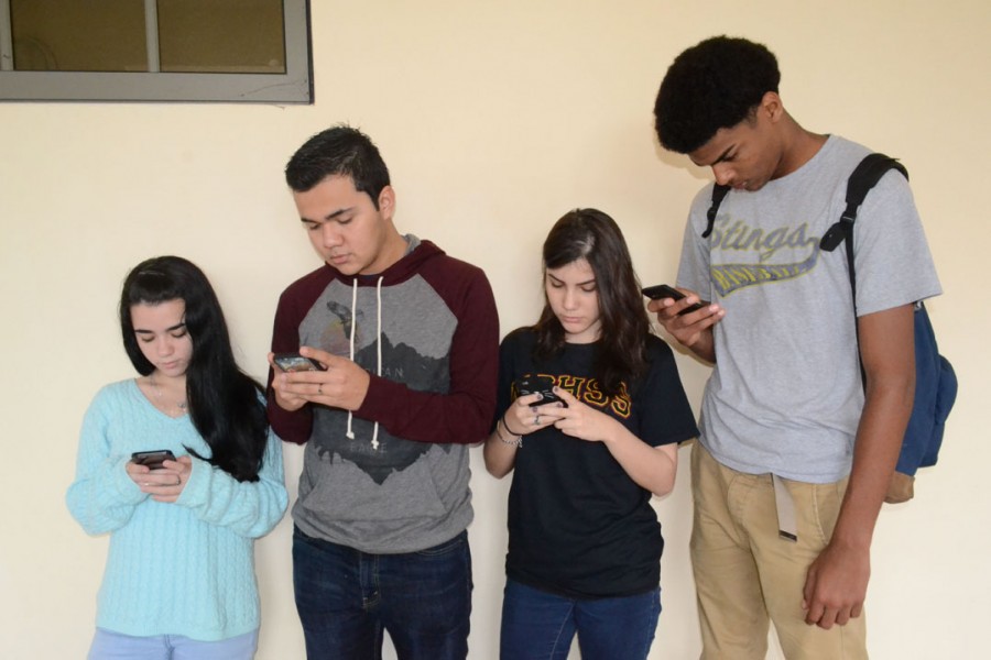 Juniors Roxana Amador, Bryan Molina and Seniors Rossangela Palacios, and Darvin Inoa on thier phones.