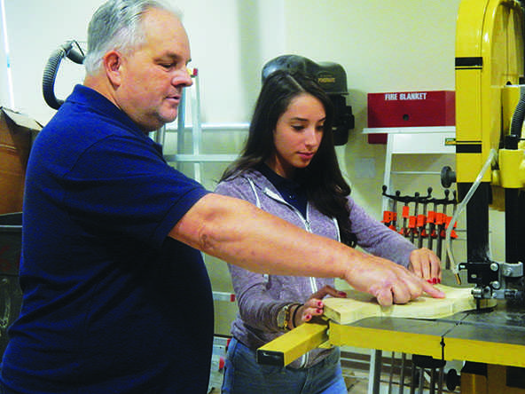 Mr. Brown assists freshman Lorena Sanchez during Wood shop class.