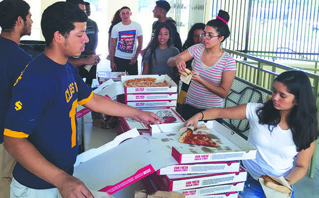 2017 Class president Headly Cash giving out pizza in the Senior crown activity.