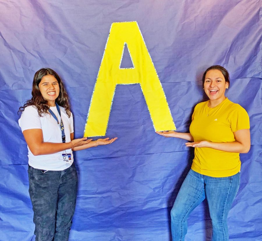 Victoria Millon (left) and Samantha Garcia (Right ) posing in front of poster