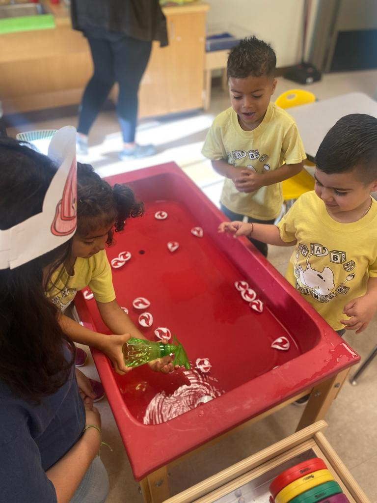 Former junior, Hyat, teaching the baby stings a science lesson by using the water sensory table.