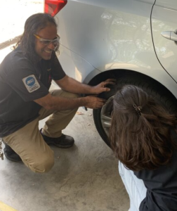 Mr. Aguiar helping out a student with  adding air to a tire.
