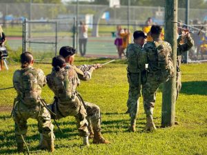 The JROTC Raiders team at a competition, doing rope bridge.