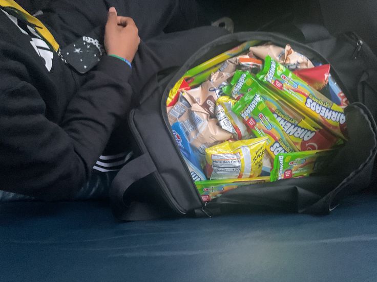An anonymous student opens their duffel bag to reveal snacks prepared for sale before arriving at Miami High.

